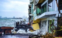AFTER THE BULKHEAD FAILED, waves continue to flood and destroy several homes along the Peninsula on Sunday, Oct. 11. 